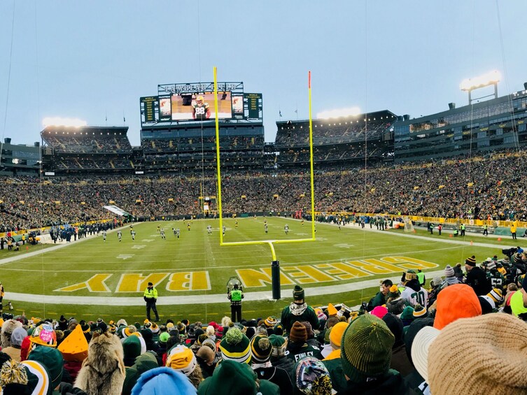 A football stadium with a large crowd, a field marked 'BIRDS,' and a scoreboard. 4
