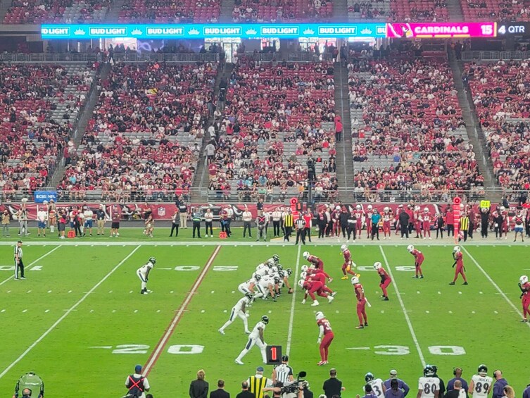 Un stade de football avec un tableau d’affichage, une foule nombreuse et des joueurs sur le terrain. 3