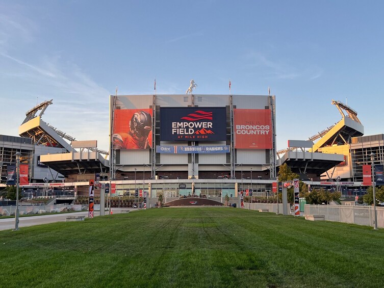 En stadion med en stor reklamskylt som visar en annons för ”Empower Field at Mile High” och ”Broncos Country”. 3