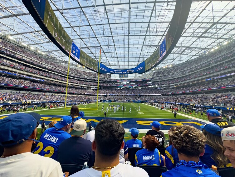 Un grand stade intérieur doté de plusieurs niveaux de gradins, d’un terrain de football et d’un tableau d’affichage. 1