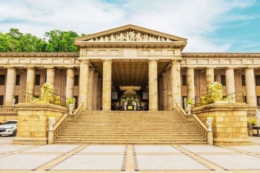 A grand building with classical architecture, featuring a central staircase, columns, and a symmetrical facade. 2