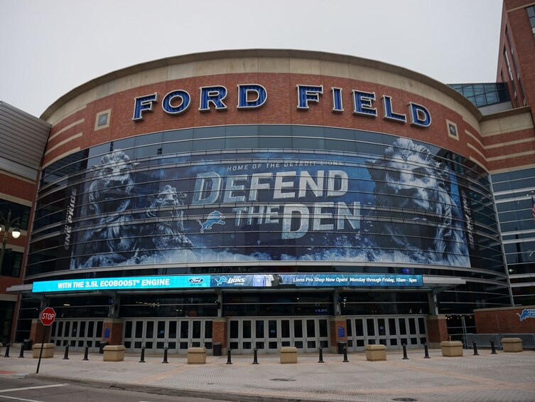 Ford Field udefra med et stort reklameskilt med teksten 'Defend the Den'. 4