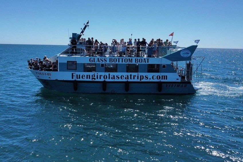 Una barca con fondo trasparente chiamata 'Fuengirolasetrips.com' con passeggeri a bordo. 3