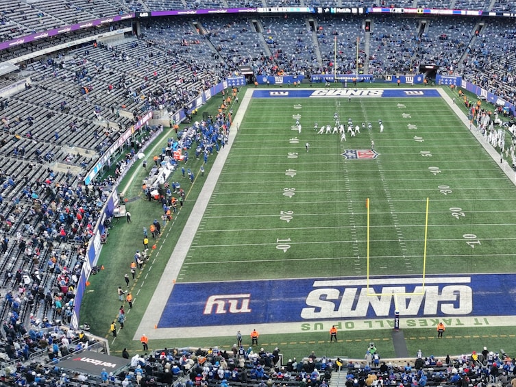 A football stadium with a large 'Giants' logo on the field, surrounded by spectators. 4