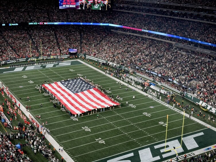 Et fodboldstadion med et stort amerikansk flag på banen. 4