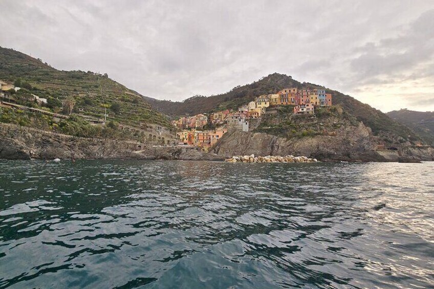 Un village côtier aux bâtiments aux couleurs vives, situé sur une colline et offrant une vue sur la mer. 3