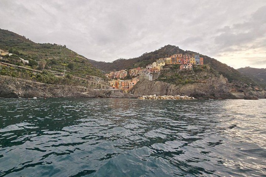 A coastal village with colorful buildings on a hillside, surrounded by water. 3