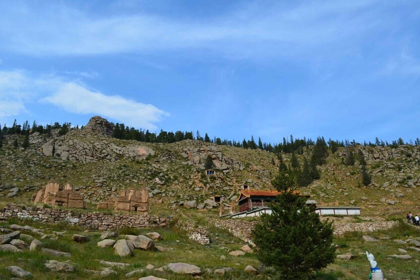 A mountainous landscape with ancient ruins and a small wooden structure. 4