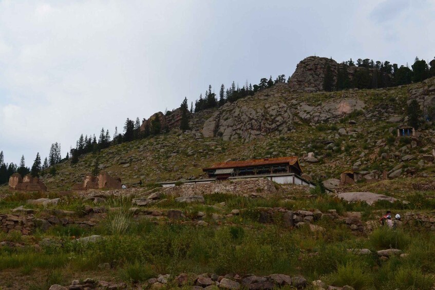 A mountainous landscape with a modern building and ancient ruins. 1
