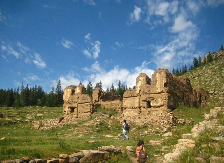 Ancient ruins with a clear sky and hikers in the foreground. 2