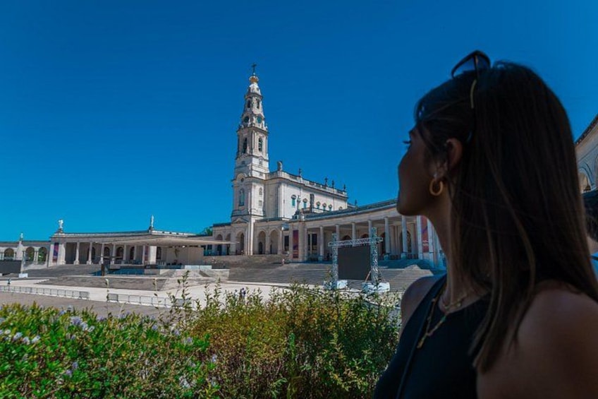 Une femme observe un bâtiment historique doté d’une haute tour. 5