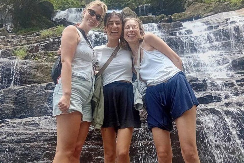 Three people standing in front of a waterfall. 5