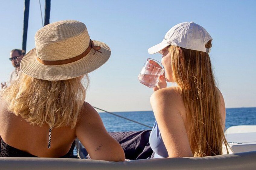 Dos personas en un bote, una con sombrero de paja y la otra con gorra blanca, ambos mirando al mar. 2