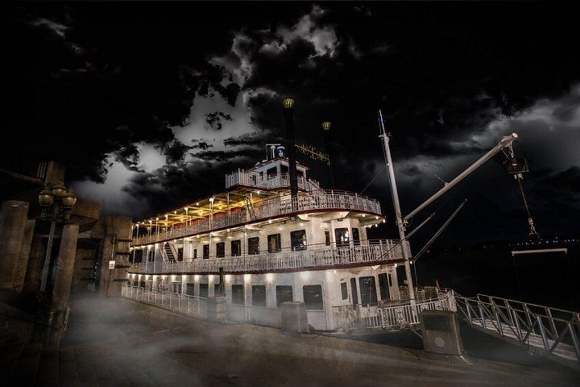 Un grand bateau à vapeur illuminé était amarré à un quai, sous un ciel nuageux. 3
