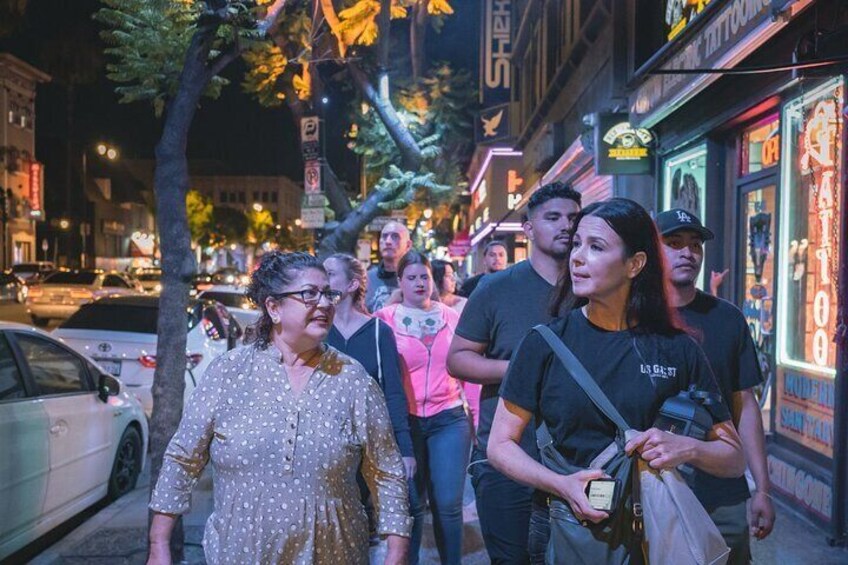 A group of people walking on a city street at night. 1
