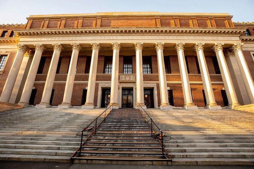 A grand building with a central staircase leading to a large entrance, flanked by columns and a brick facade. 5