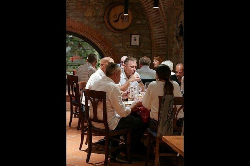 Persone che cenano in un ristorante con pareti in mattoni e un orologio. 4