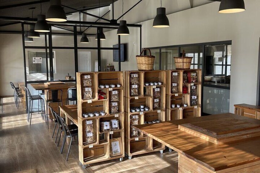 A café with wooden tables and chairs, shelves with jars of tea, and hanging baskets. 4