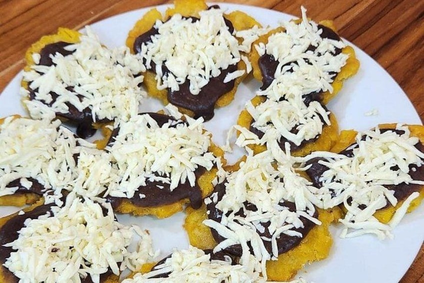 Une assiette de nourriture composée de tranches recouvertes de fromage râpé et d’une sauce foncée. 3
