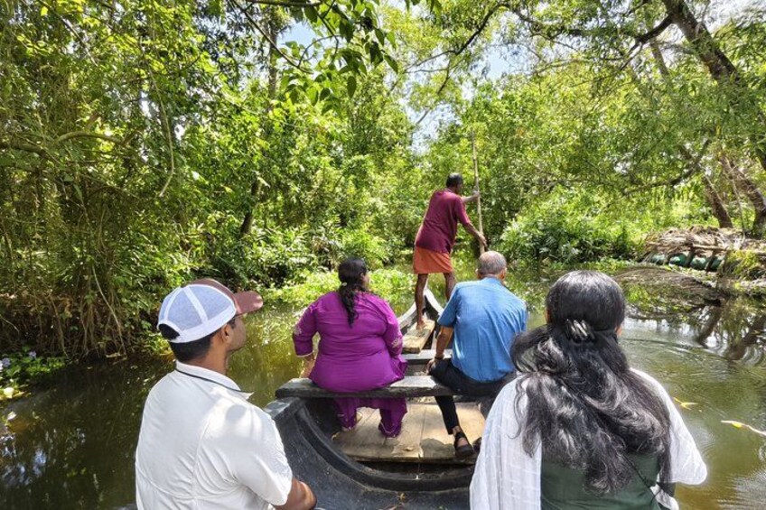 People on a boat in a forested area with dense greenery and a calm river. 2