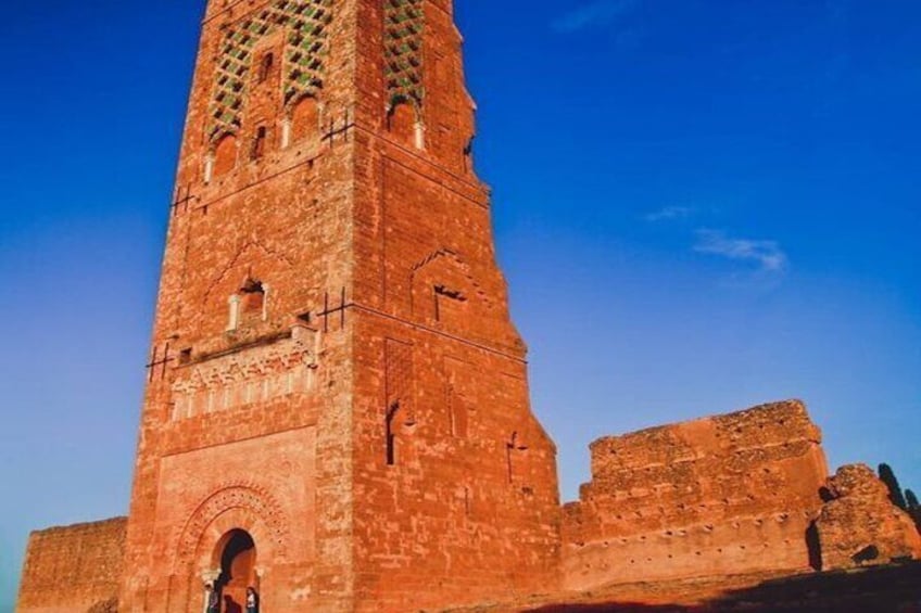 A tall brick tower with arched windows and a smaller adjacent structure. 3