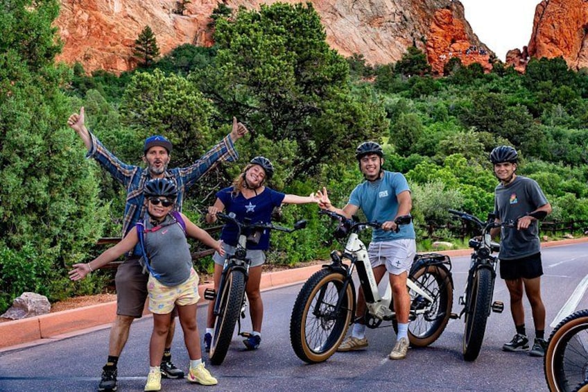 Un groupe de cyclistes sur une route, avec en arrière-plan des formations rocheuses rouges. 4