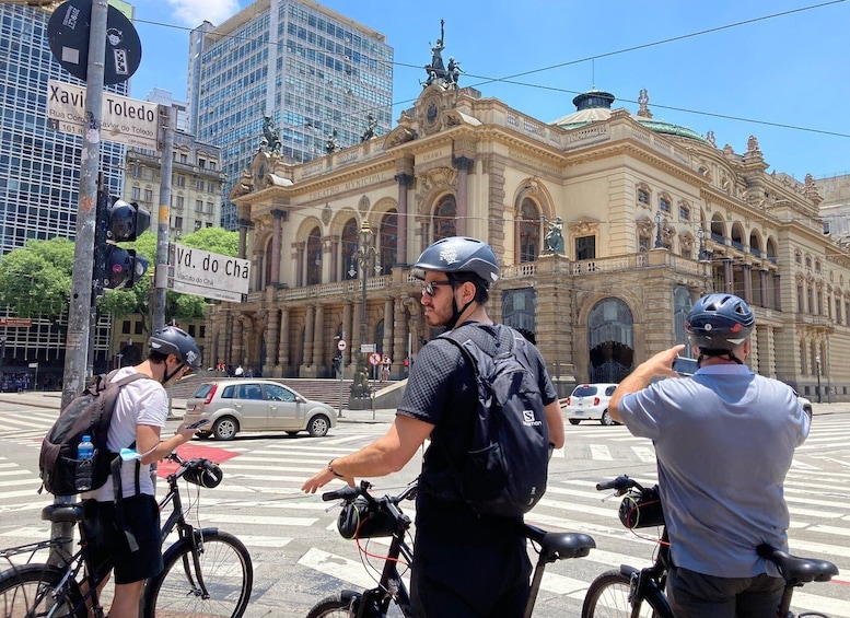 A street scene with cyclists, a historic building, and traffic signs. 1