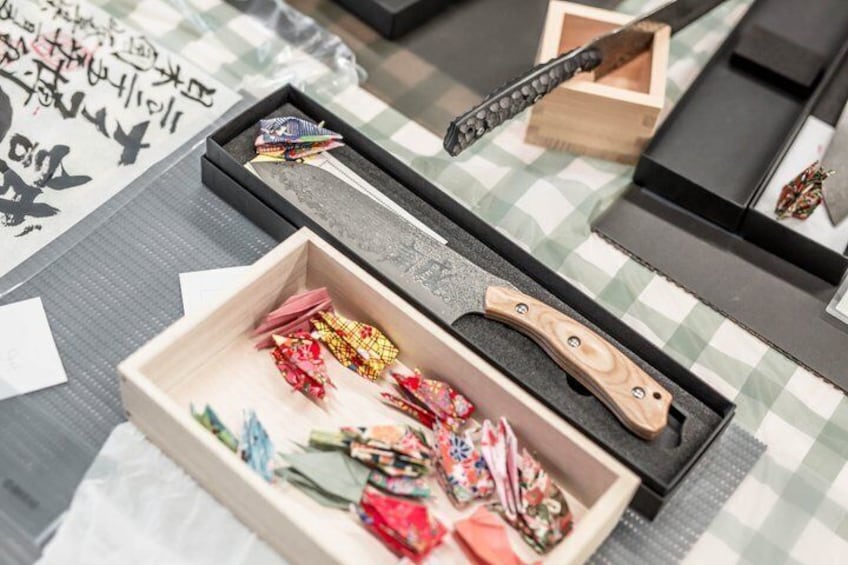 A table with a checkered tablecloth, a wooden box, and a knife. 3