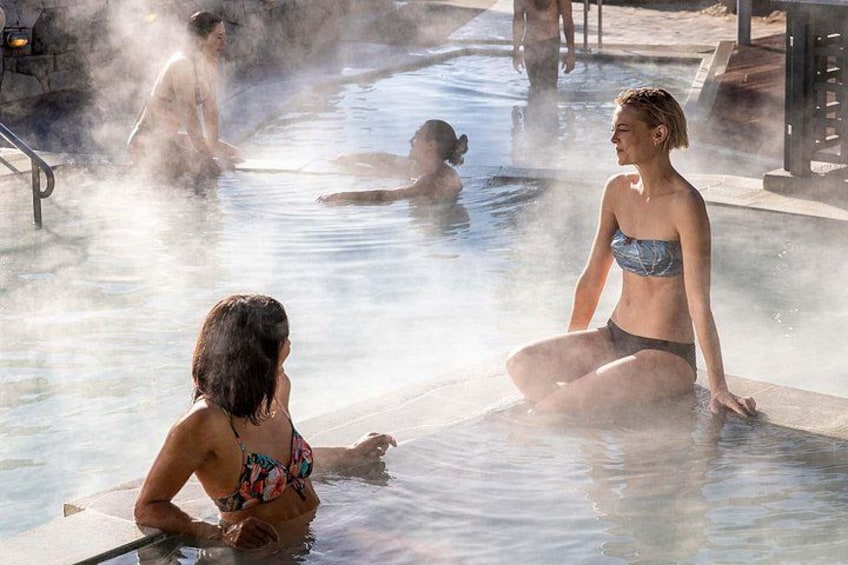 A hot spring with people sitting and relaxing in the water. 1