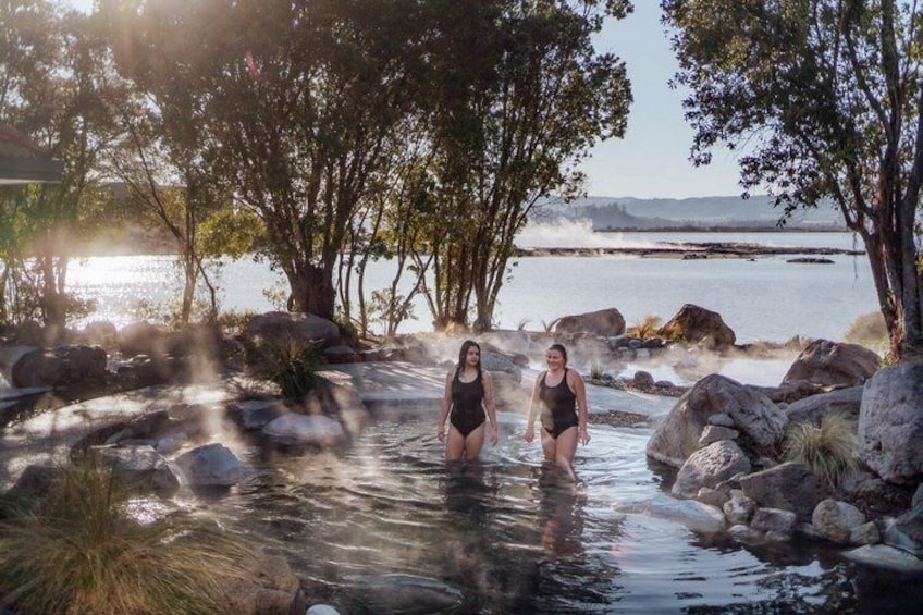 Zwei Personen in einer natürlichen Umgebung mit Wasser, Felsen und Bäumen. 2