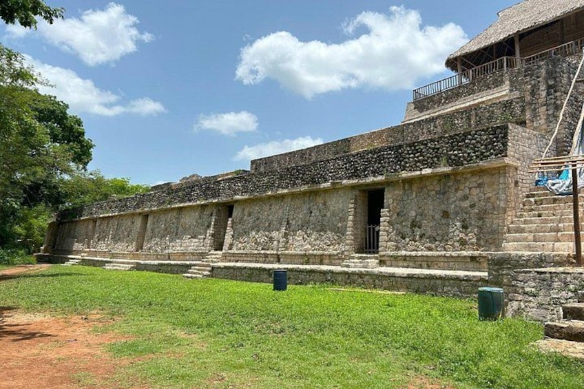 A stone building with a thatched roof, surrounded by a grassy area. 5