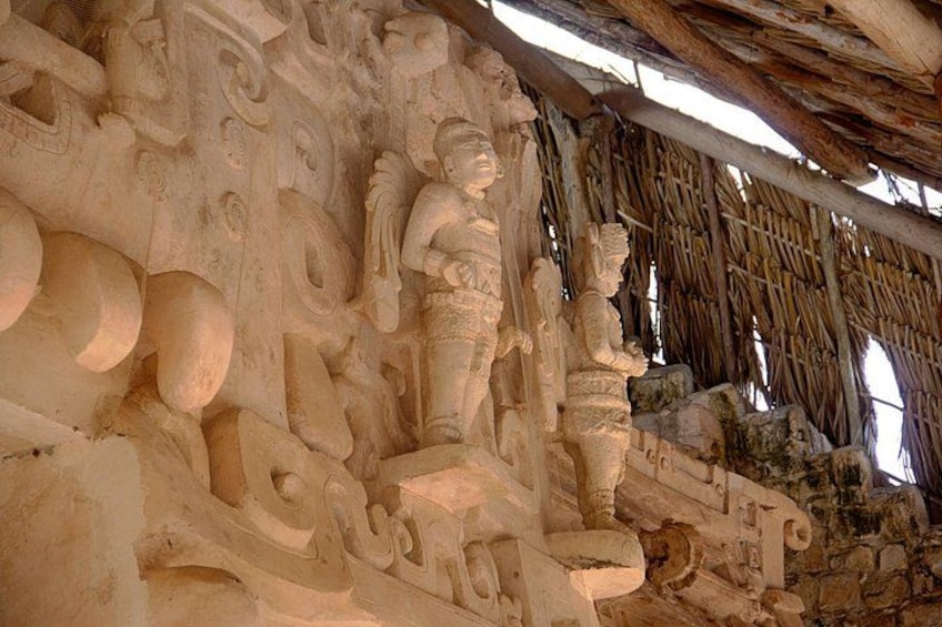 Ancient stone carvings and a thatched roof structure. 3