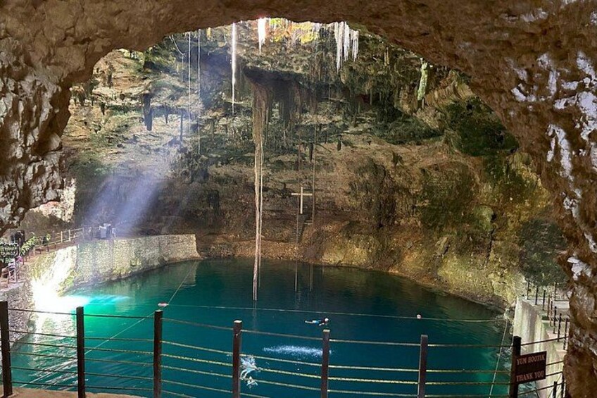 A cave with a pool of water, stalactites, and a wooden walkway. 2