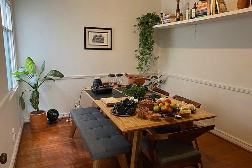 A wooden dining table with a bench, surrounded by chairs, a potted plant, and a blender. 3