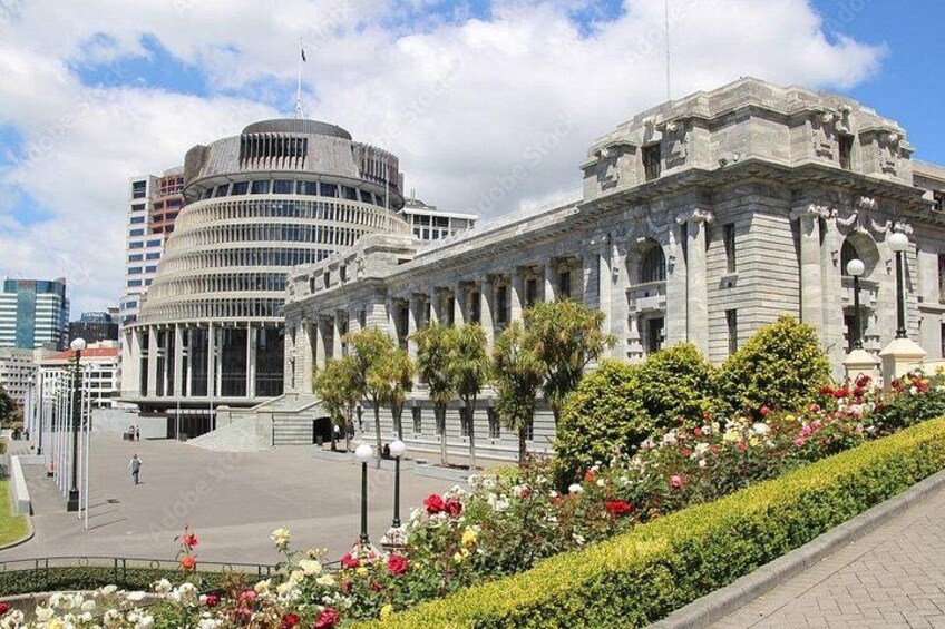 A historic building with classical architecture, surrounded by a well-maintained garden with various flowers. 4