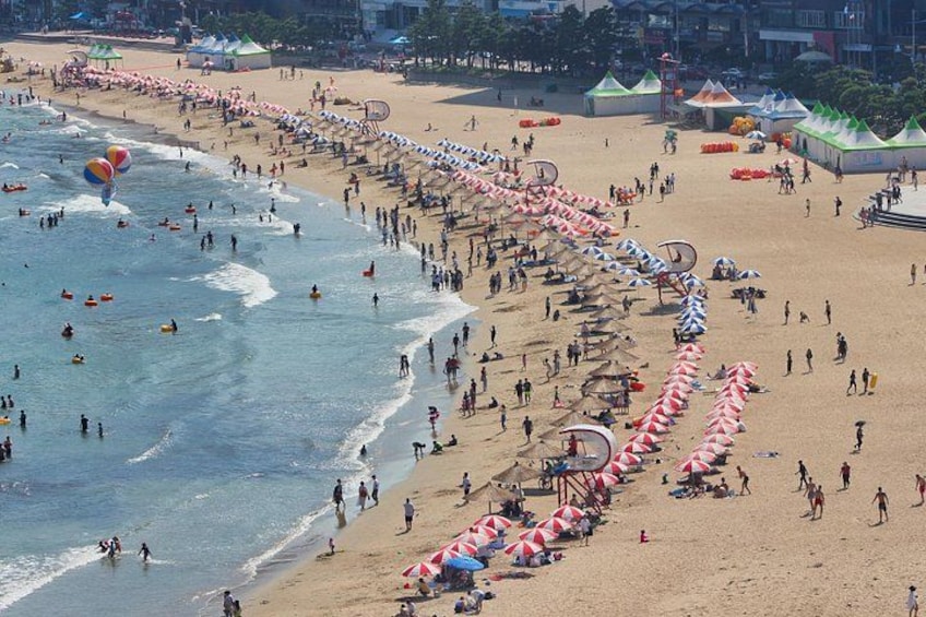 Una playa concurrida, gente, sombrillas y sillas de playa. 3