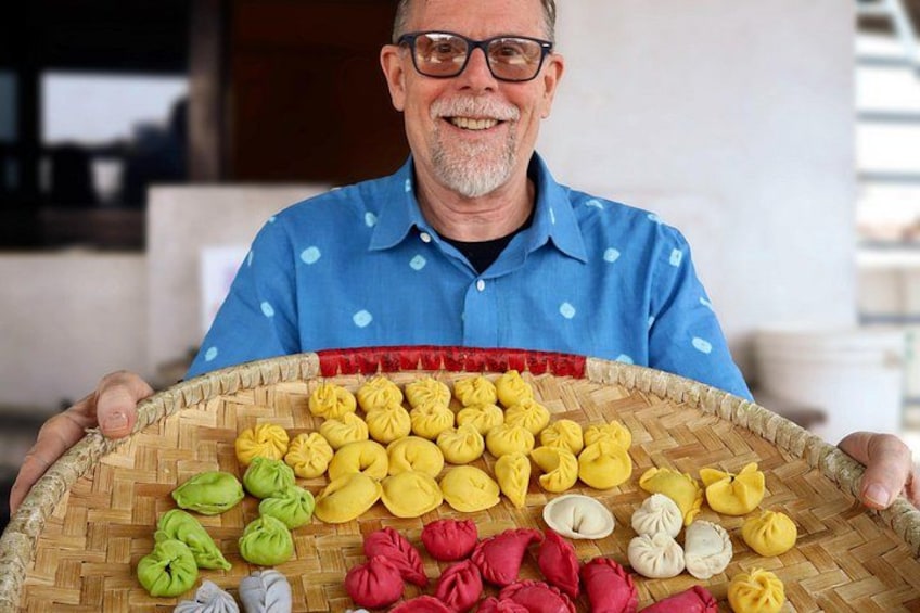 Une personne tenant un panier tressé rempli de différents types de raviolis. 5