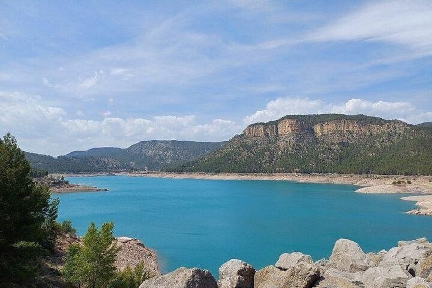 Un paysage côtier avec une mer bleue et limpide, une côte rocheuse et une montagne en arrière-plan. 2