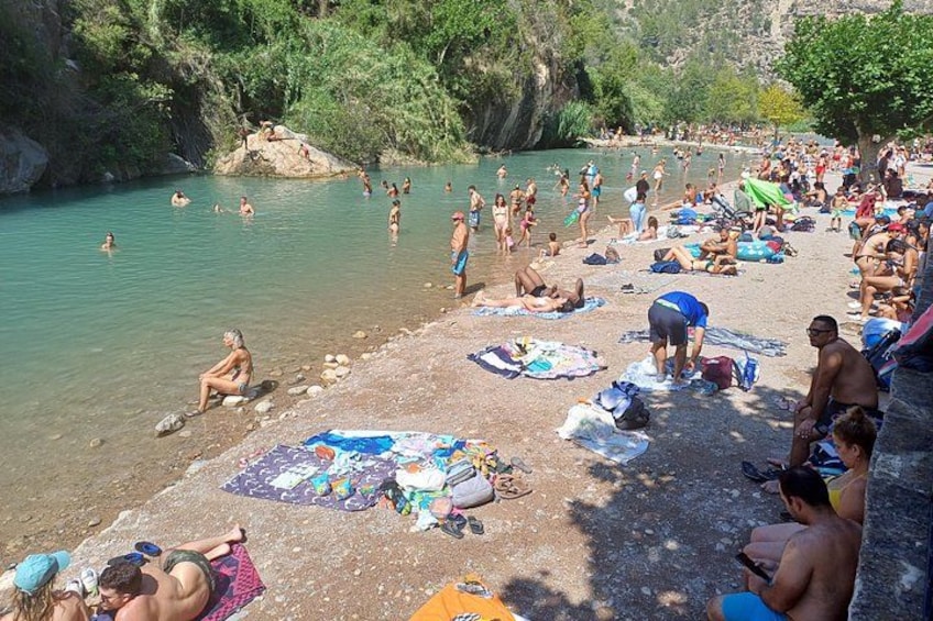 Une plage bondée où les gens se baignent et prennent des bains de soleil. 5