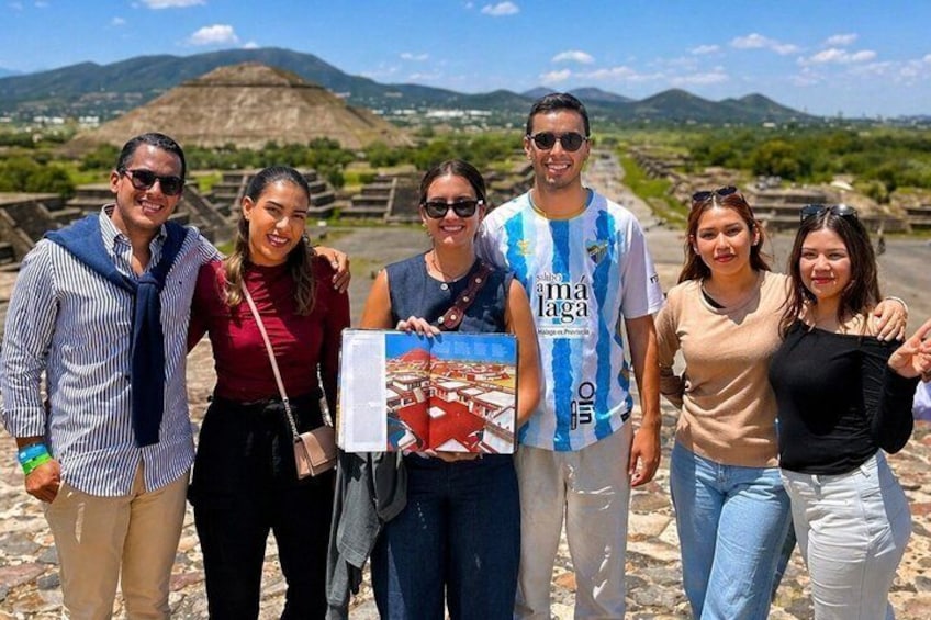 A group of people standing on a rocky terrain with a mountainous landscape in the background. 4