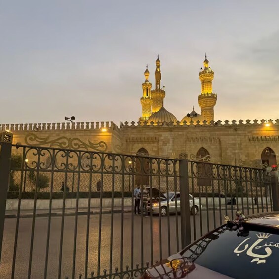 Una mezquita con dos minaretes y una cúpula grande, rodeada por una entrada con reja. 5
