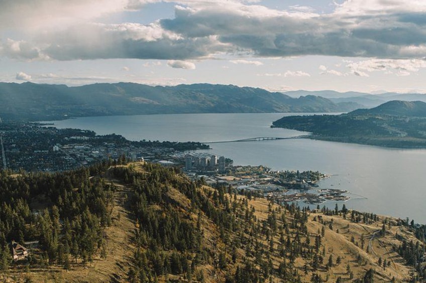 Un paysage montagneux avec un lac, une ville et des zones boisées. 3