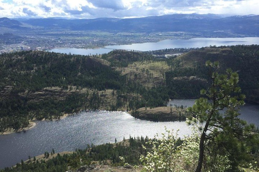 Un lac entouré de collines boisées, une ville lointaine et un ciel dégagé. 2