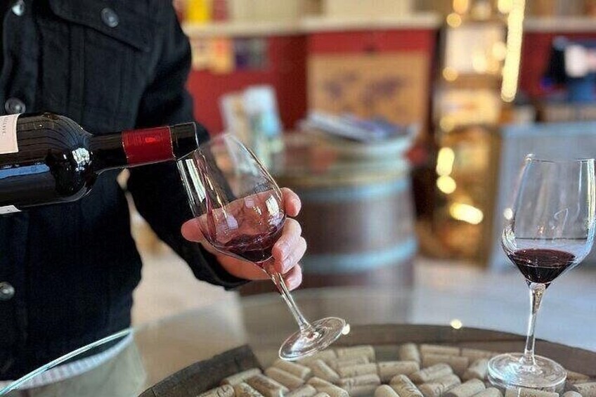 A person pouring wine into a glass. 2