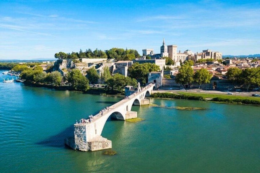 A river with a stone bridge, a cityscape with historic buildings, and a clear sky. 1