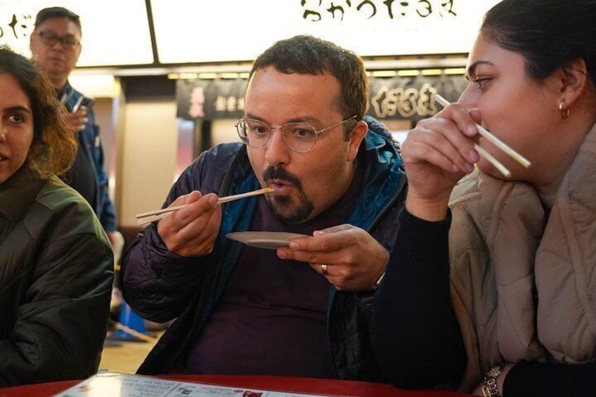 Personas comiendo en un restaurante con palillos. 3