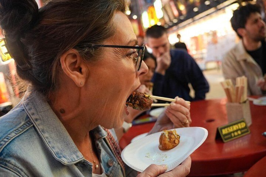 Una persona comiendo con palillos en un restaurante. 2