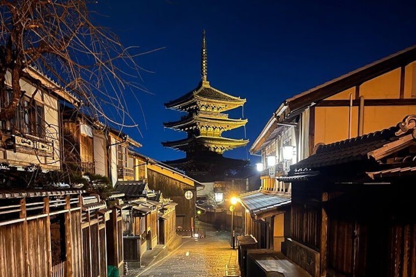 Une rue traditionnelle japonaise de nuit, avec une pagode en arrière-plan. 1