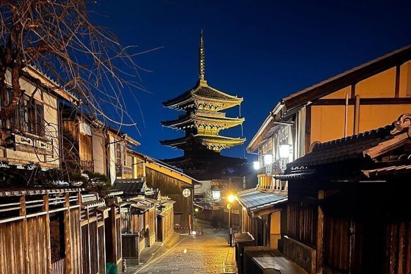 Une rue typique du Japon, de nuit, avec une pagode en arrière-plan. 1