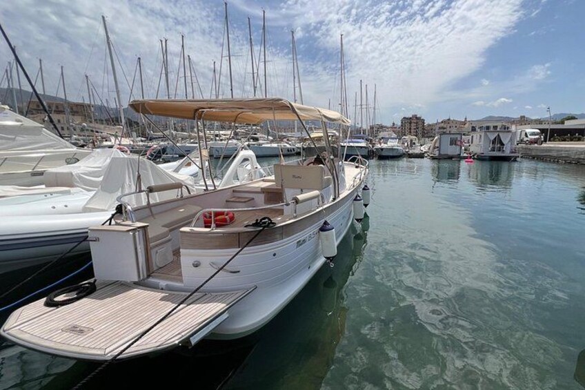 Un port de plaisance avec plusieurs bateaux amarrés, une eau calme et des bâtiments en arrière-plan. 3